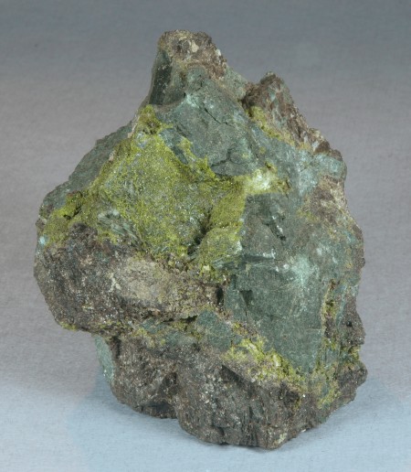 Dark green, rock-locked crystals of actinolite intergrown with massive, dark brown garnet
