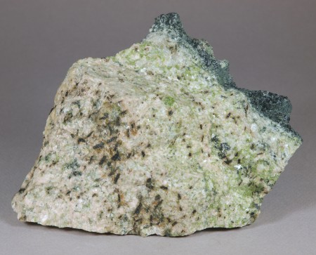 Glassy, nearly black allanite, most 4-7 mm in length on ivory-colored feldspar partly altered to green epidote