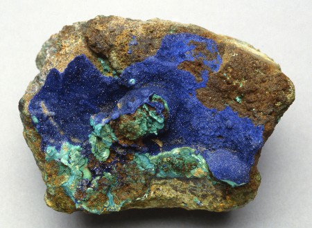 Druse of tiny, lustrous azurite crystals associated with dull green malachite on limonitic matrix