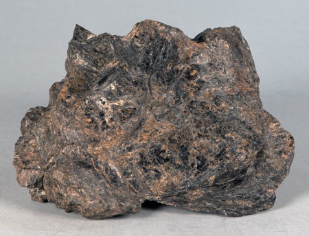 Coarse-grained, intergrown, platy masses of dark brown bannisterite