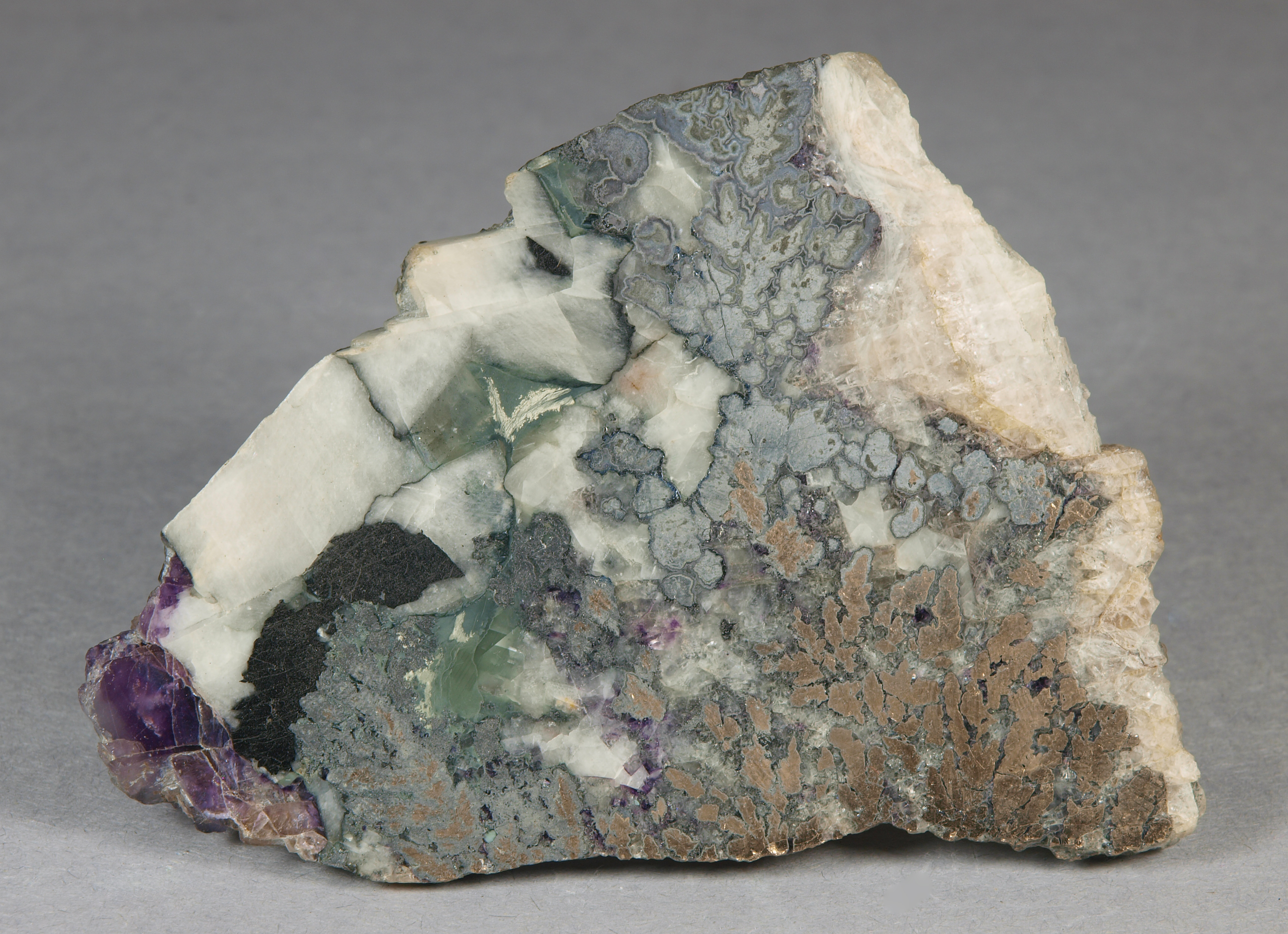 Dendritic mass of nickeline and associated arsenide minerals, tiny, pale violet blebs breithauptite