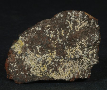 Pale yellow hemispheres of dypingite on willemite-franklinite-calcite "red ore"