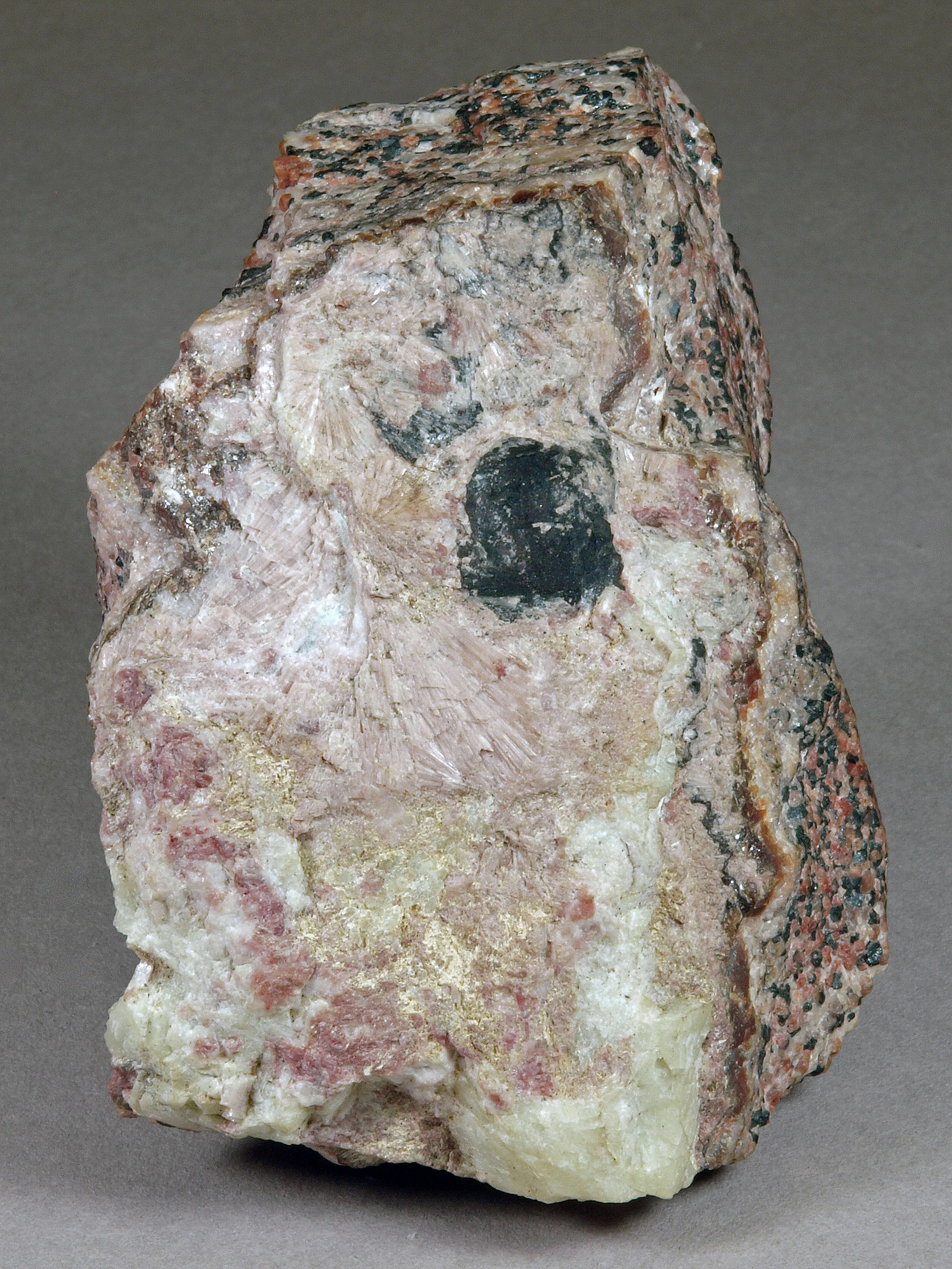 Radiating pale pink gerstmannite crystals on pale green willemite,white calcite and black pyrochroite