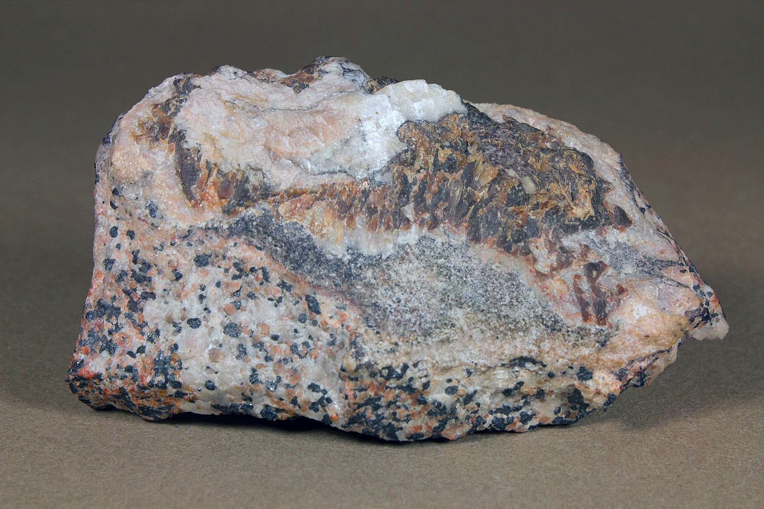 Faintly pink gerstmannite, white calcite, massive brown sphalerite, granular willemite-franklinite-calcite ore