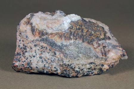 Faintly pink gerstmannite, white calcite, massive brown sphalerite, granular willemite-franklinite-calcite ore