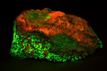 Faintly pink gerstmannite, white calcite, massive brown sphalerite, granular willemite-franklinite-calcite ore under blue (445 nm) UV Light