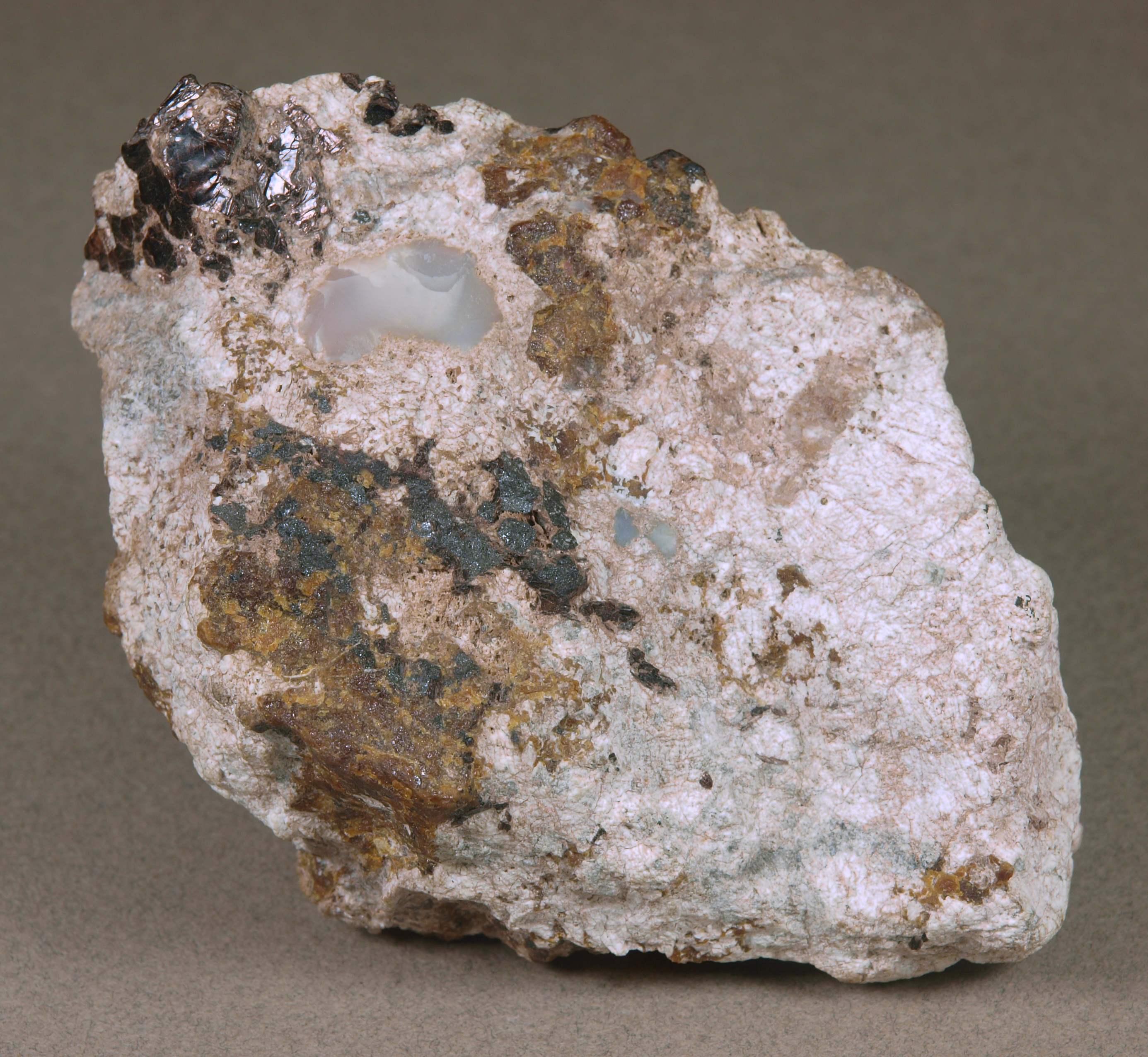 Gypsum, white roeblingite, massive brown andradite, franklinite, brown plates of hendricksite