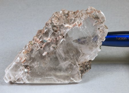 Gypsum, var. selenite, colorless and nearly transparent, numerous included grains of franklinite and altered, calcite. 