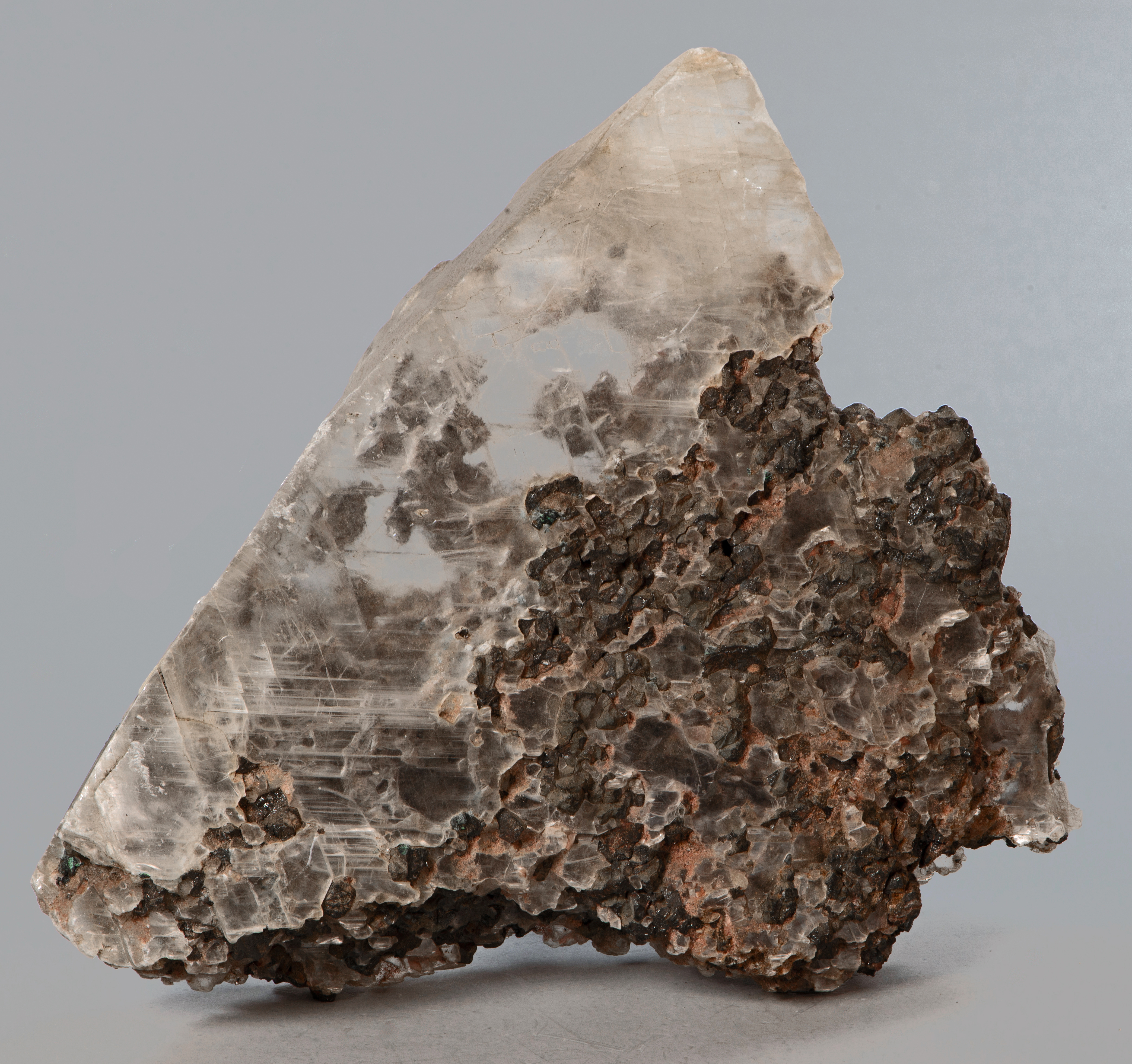 A cleavage plate of gypsum (var. selenite), grains of franklinite and calcite cemented together by the gypsum