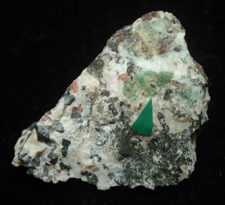 Thin, patchy, pale blue coating of lavendulan, in tiny spheroids on granular willemite-franklinite-calcite ore.