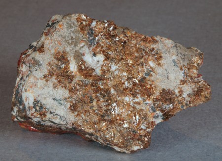 Assemblage of glassy, dark brown magnussonite with bright orange-red zincite