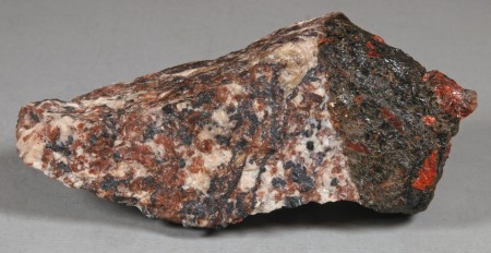 Dark brownish-green, somewhat glassy, massive magnussonite in altered, sheared, franklinite-willemite-calcite ore. 