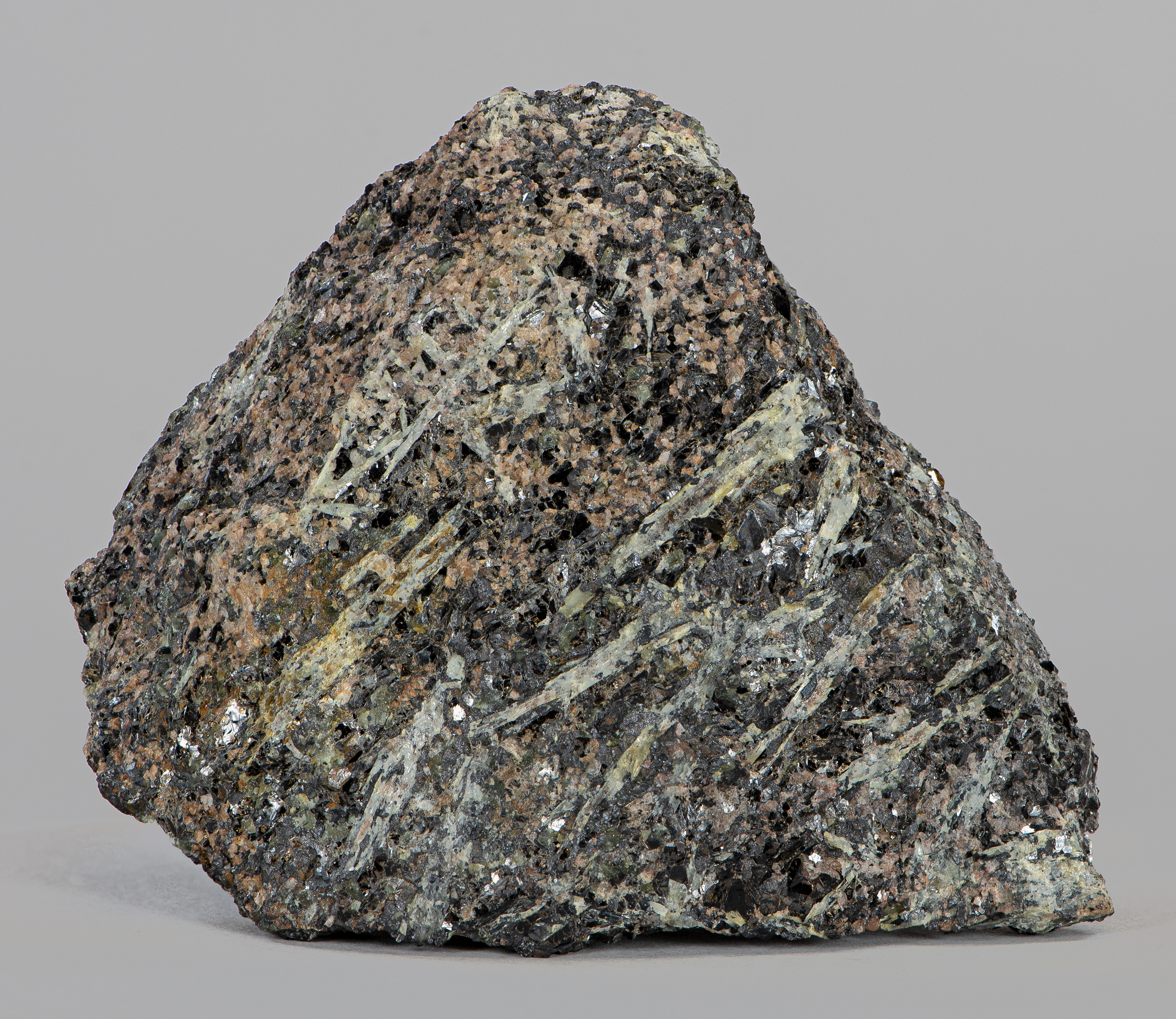 Abundant, pale greenish yellow, bladed, tapering crystals of sillimanite in feldspar-quartz-magnetite gneiss with minor apatite