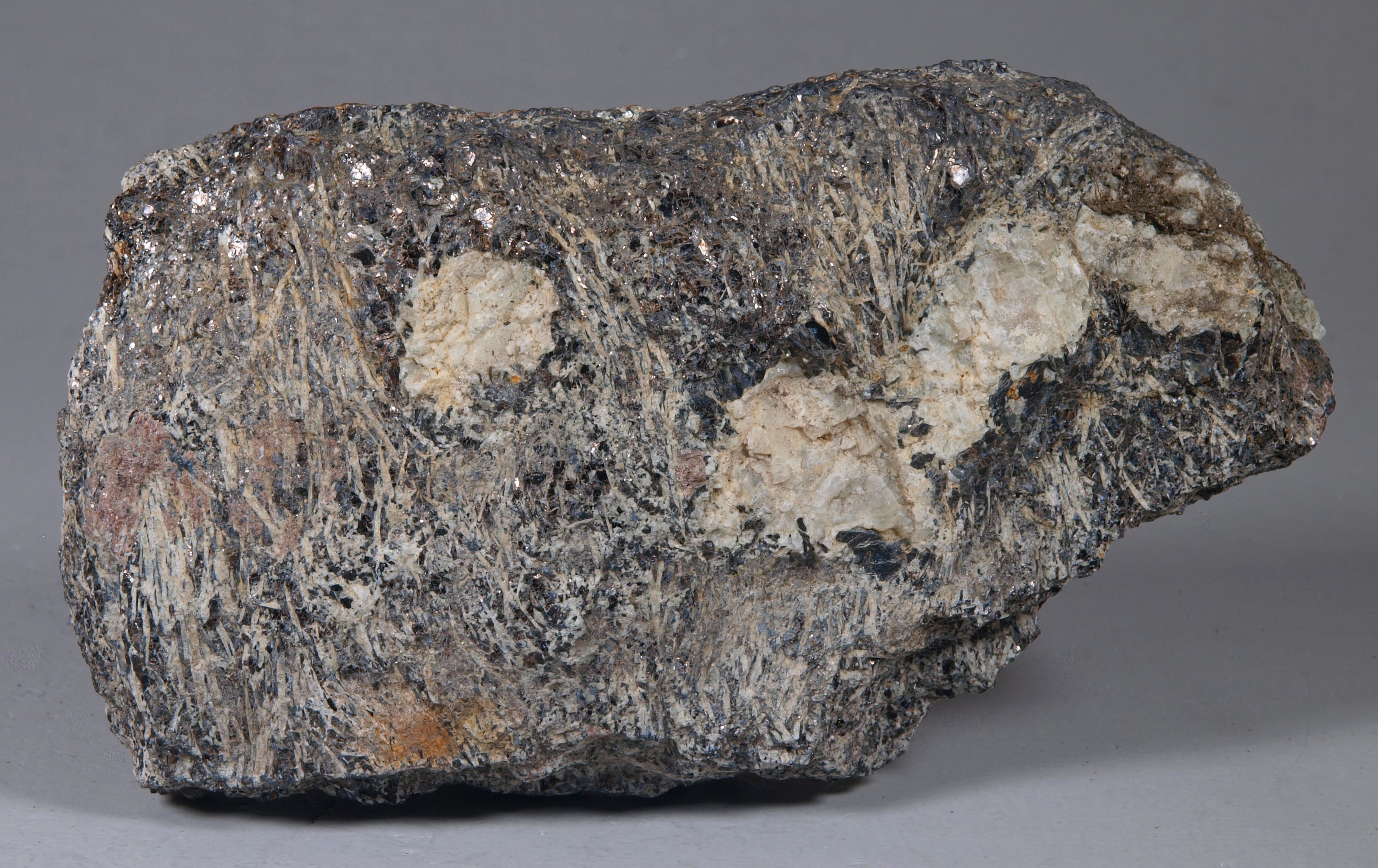 Slender, white, needlelike crystals of sillimanite with biotite in a biotite-sillimanite-feldspar-magnetite-garnet gneiss