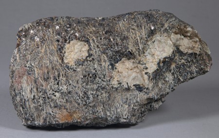 Slender, white, needlelike crystals of sillimanite with biotite in a biotite-sillimanite-feldspar-magnetite-garnet gneiss