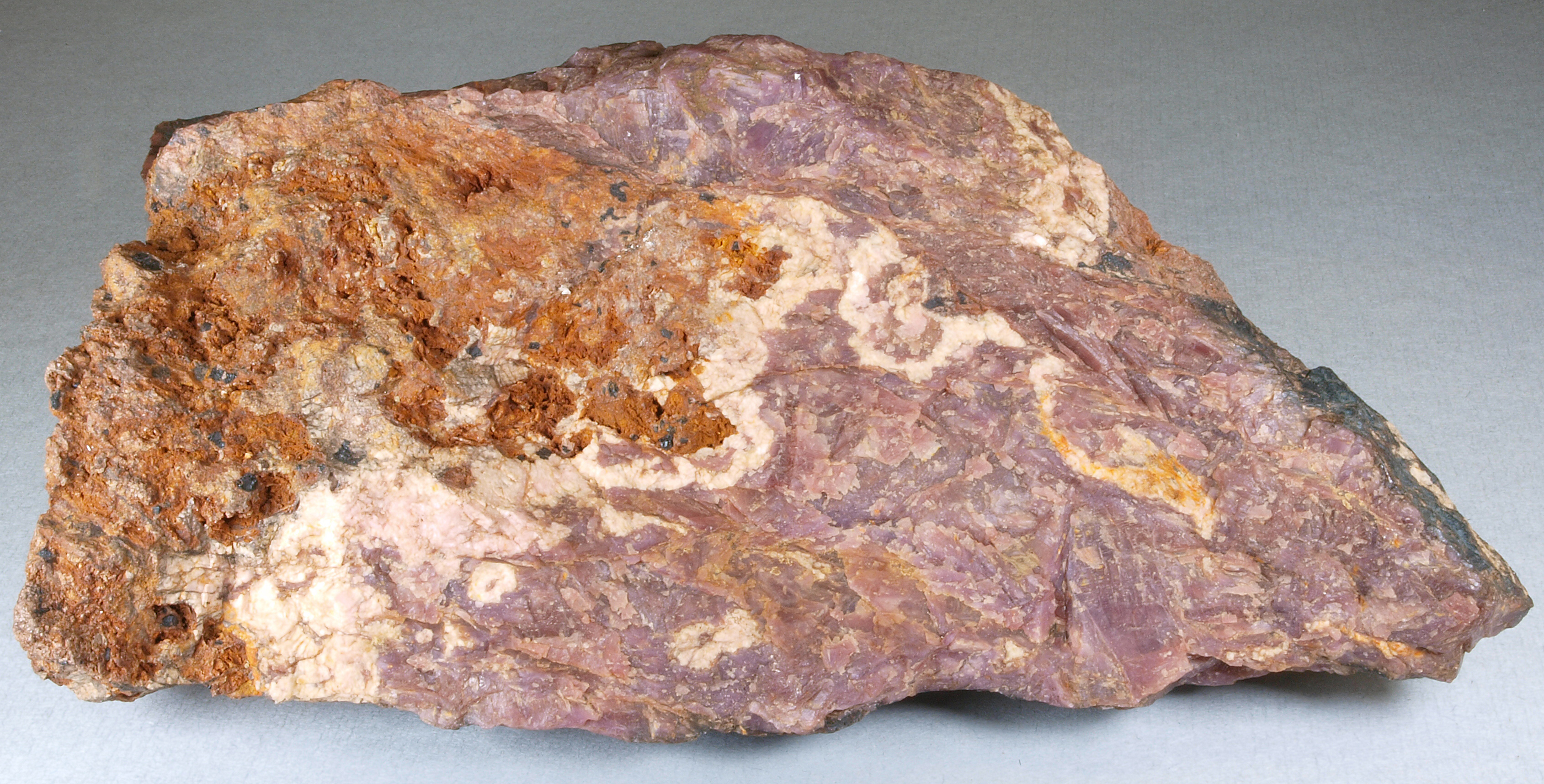 Purplish sussexite, brownish orange zincite, white calcite, Sterling mine, Ogdensburg