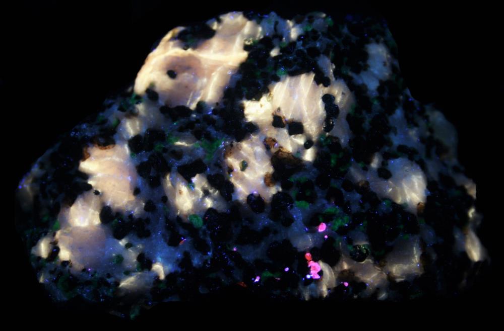 Yellow Fluorescent calcite, willemite, franklinite and minor sphalerite, Sterling Hill Mine, NJ. under longwave UV Light