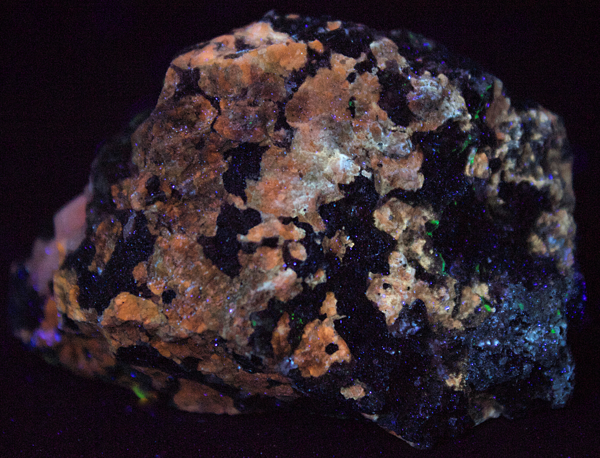 Cuspidine, calcite, willemite, and franklinite from Franklin, NJ under longwave UV Light