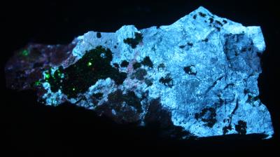 Margarosanite on feldspar with andradite and minor willemite from Franklin, NJ under shortwave UV Light