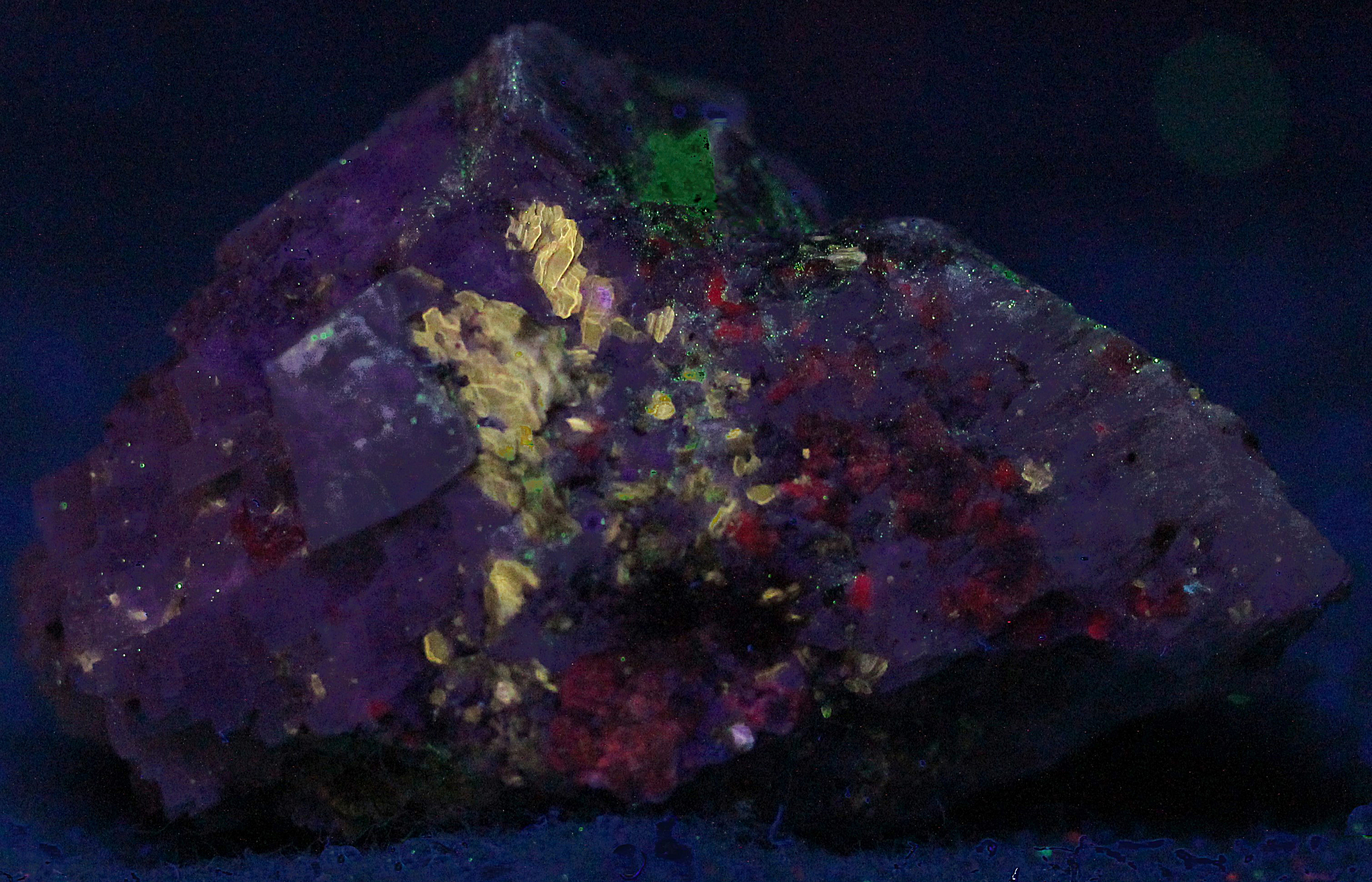 Phlogopite mica and corundum in marble, from Franklin, NJ under shortwave UV Light
