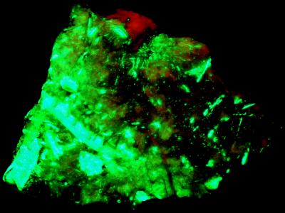 Rhodochrosite, willemite crystals and minor calite from Franklin, NJ under shortwave UV Light