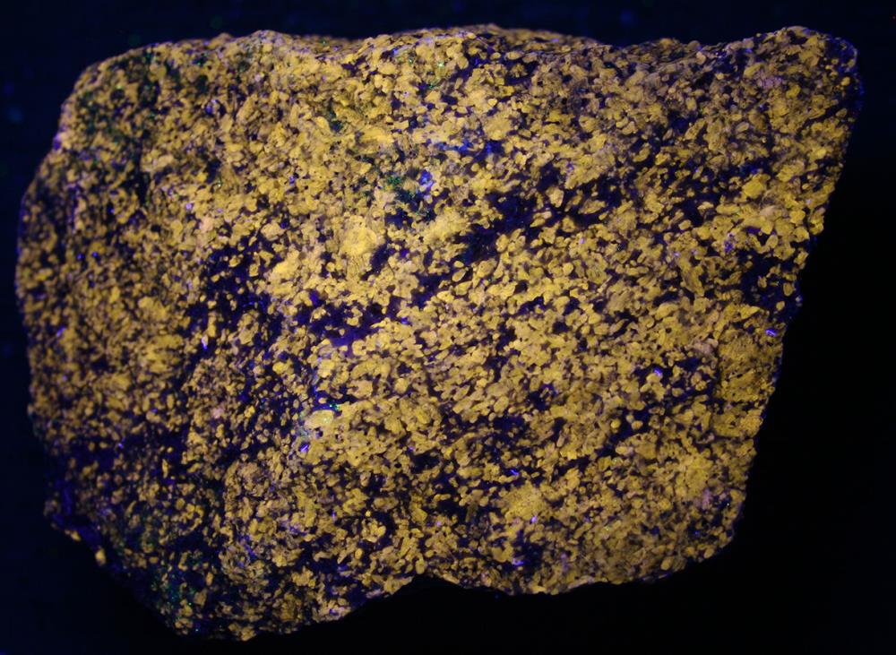 Wollastonite in calcite, pyrite, diopside Sterling Hill Mine under shortwave UV Light